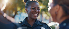 Smiling female police officer enjoying a light moment with a colleague.