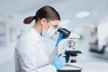 Poster - Female scientist using a microscope in office