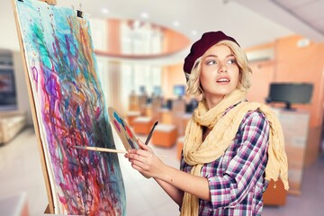 Wall Mural - Young happy artist hold brush painting canvas