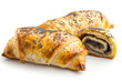 A close-up view of two golden, flaky pastry rolls filled with sweet poppy seed filling, isolated on a white background