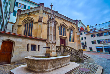 Canvas Print - The old fountain on Zwingliplatz next to Grossmunsterkapelle, Zurich, Switzerland