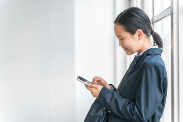 Poster - 学校の教室でスマホを使う中学生・高校生・小学生の女の子（アプリ・SNS・インターネット・青春）
