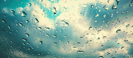 Poster - Close-up view of raindrops on the window of a car, with a background of a cloudy sky. The water droplets create a pattern on the glass, illuminated by the outside light.