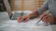 © FAMILY STOCK - Close-up of businesswoman's hands checking company finances and earnings and budget with graph on the desk in the office..