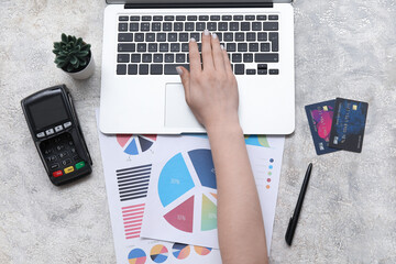 Canvas Print - Female hand with laptop, credit cards and charts on grey grunge table. House rent concept