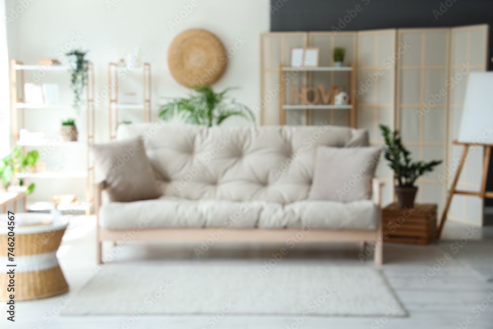 Interior of stylish living room with grey sofa, blurred view