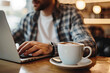 © Emanuel - Balancing Work and Leisure: A Young Man with a Coffee Cup, Engaging with a Laptop