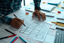 Website Designer Developing UI/UX Design with Sketched Notes, Wireframe Layouts for Mobile Application Project