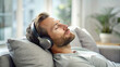 © Zhangxiao - Relaxation Mode: Man Lounging on Sofa, Eyes Closed, Enjoying Music with Headphones