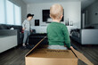 Rear view of little boy standing in cardboard box