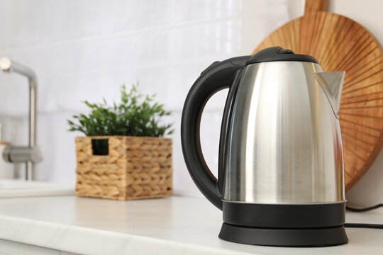 Modern electric kettle on counter in kitchen. Space for text