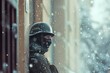 A distant view of a soldier with a mask and helmet, standing guard outside a building, snow gently falling around, creating a soft, blurred background.