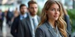 © Iryna - A young, blonde, and attractive businesswoman leads a happy and confident team in a modern office hall.