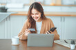 © oatawa - Online payment, Happy asian woman holding a credit card and using smart phone and laptop for online shopping