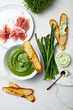 Healthy asparagus, green peas, watercress cream soup with toasted bread, prosciutto and wild garlic, ramson cream cheese