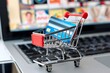 small shopping cart and credit card in front of a laptop computer in a style of saturated stripes, This image is suitable for online shopping e-commerce payment and business related themes