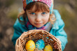 child holding a basket with vibrantly decorated Easter eggs , generative AI