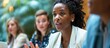 © Emin - Black businesswoman speaking to colleagues during board meeting.