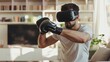 Man using virtual reality glasses and boxing gloves practices home sports in his apartment, boxing in cyberspace
