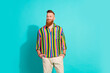 Photo of young handsome macho red hair beard guy well groomed look thoughtful and mysterious isolated on aquamarine color background