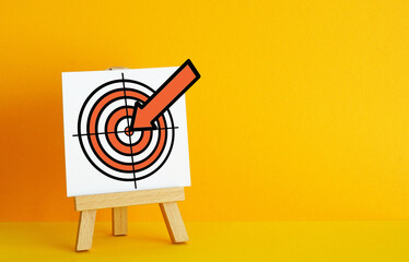 Poster - Archery target on a orange background. The concept of fulfilling the goal, striving to implement plans. Target with embedded arrow
