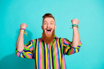 Photo of successful red hair guy raised fists up celebrate millionaire lottery tick become rich isolated on aquamarine color background