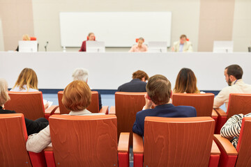 Audience sitting in front of panel at convention center