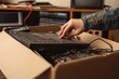 Woman hands put old laptop computer in cardboard box with old used tech gadget devices for recycling. Planned obsolescence, e-waste, electronic waste for reuse, refurbish, recycle, Generative AI