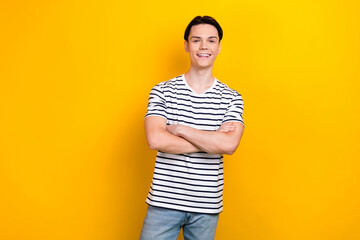 Wall Mural - Photo of cheerful guy with stylish hairdo dressed striped t-shirt standing arms crossed isolated on vibrant yellow color background