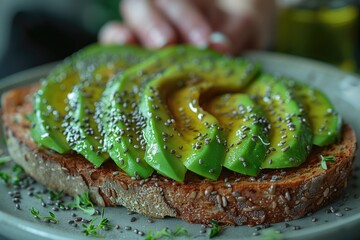 Wall Mural - Superfood Snacking: A fitness enthusiast enjoys a mid-day snack of sliced avocado on whole-grain toast, sprinkled with nutrient-rich chia seeds and a drizzle of olive oil