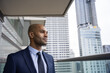 © ReeldealHD images - African American businessman on office balcony looking confidently at city skyline