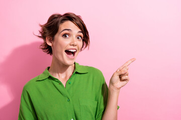 Wall Mural - Photo portrait of attractive young woman excited finger point empty space dressed stylish green clothes isolated on pink color background