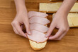 Układać plastry szynki na kanapce posmarowanej masłem z bliska