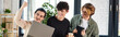© LIGHTFIELD STUDIOS - Three young men engaged in a lively discussion over a laptop at a coworking space, success banner