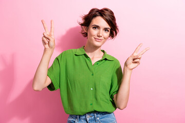 Wall Mural - Photo of good mood positive young lady wear green shirt showing two v-signs isolated pink color background
