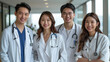 © aekkorn - group of Asian handsome male doctors and smiling Asian beautiful female doctors standing together.