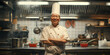 © krit - A smiling chef in traditional white attire and tall chef's hat stands confidently in a commercial kitchen.