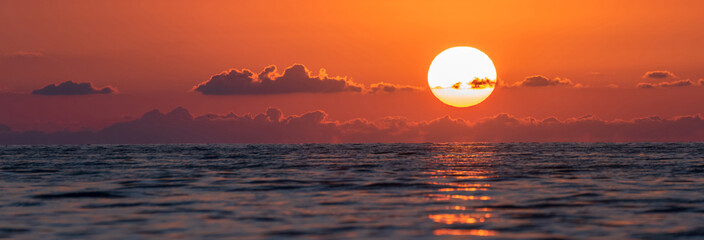 Wall Mural - The red sun sets in the sea