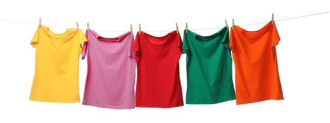 Wall Mural - Different bright t-shirts drying on washing line against white background