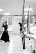 Black and white martial arts background with blur and silhouettes of people practicing with a katana sword.