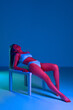© master1305 - Passion and sensuality. Beautiful young woman with slim body posing on table in underwear against blue studio background in neon light. Concept of body and health care, sport, female beauty, wellness
