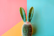 Cactus in shape of Easter bunny rabbit on colored background.