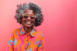 Front view of senior hipster Afro American woman with modern clothes and sunglasses over colorful pink background with copy space
