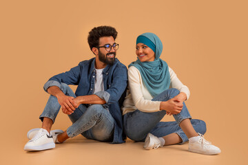 Poster - Romantic Young Muslim Couple Sitting On Floor And Looking At Each Other