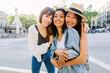 Portrait of three group of diverse young girls standing at city street. Female friendship and vacation concept.
