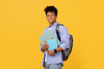 Wall Mural - Smiling black student guy with backpack holding books