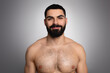 Studio shot of handsome bearded arab man posing shirtless