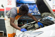 © JackF - Skilled car mechanician changing filter in vehicle in the auto repair shop