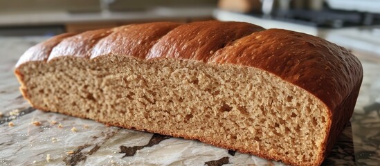 Wall Mural - A loaf of tasty brown wheat bread sits atop a kitchen counter. The wholesome delight is packed with essential nutrients, ready to be enjoyed.