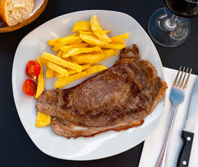 Wall Mural - Juicy grilled beef filet steak served with side dish of crispy roasted potatoes and fresh tomatoes..